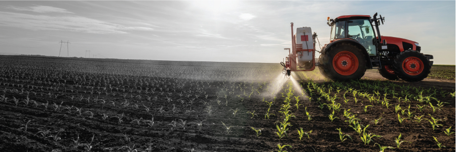 Image of a tractor spraying a field of crops