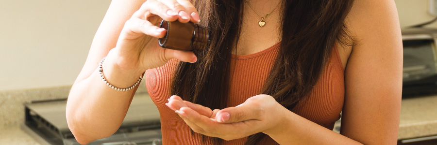 Image of a person with supplement bottle